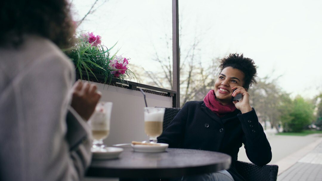 Woman smiling while talking with a friend outdoors