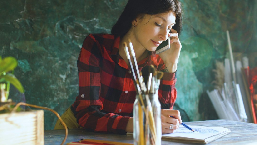 Woman writing in a notebook at a wooden desk