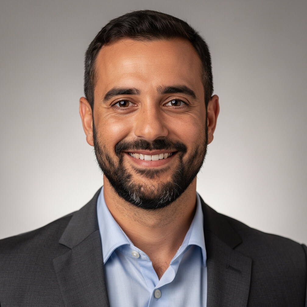 Professional headshot of a smiling man with a beard