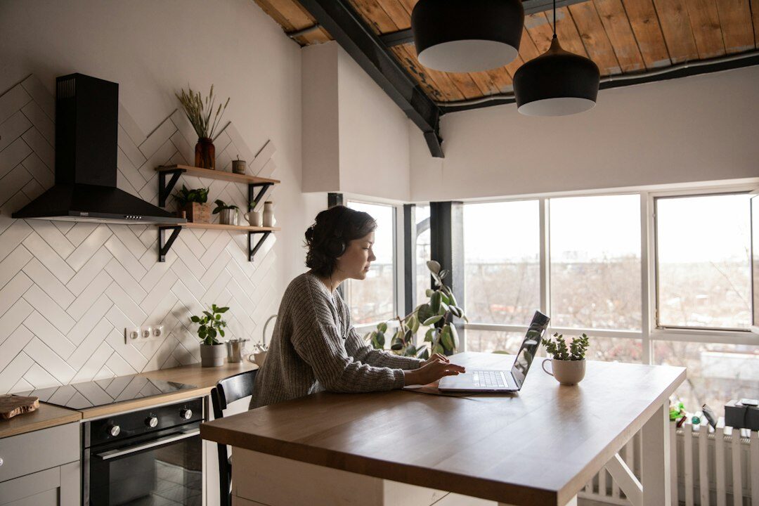 Woman typing on a laptop at a bright desk